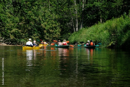 People in kayaks on water during kayaking in nature reserve "Refuge of beavers on the Pasleka river" in Warmia and Mazury, Poland