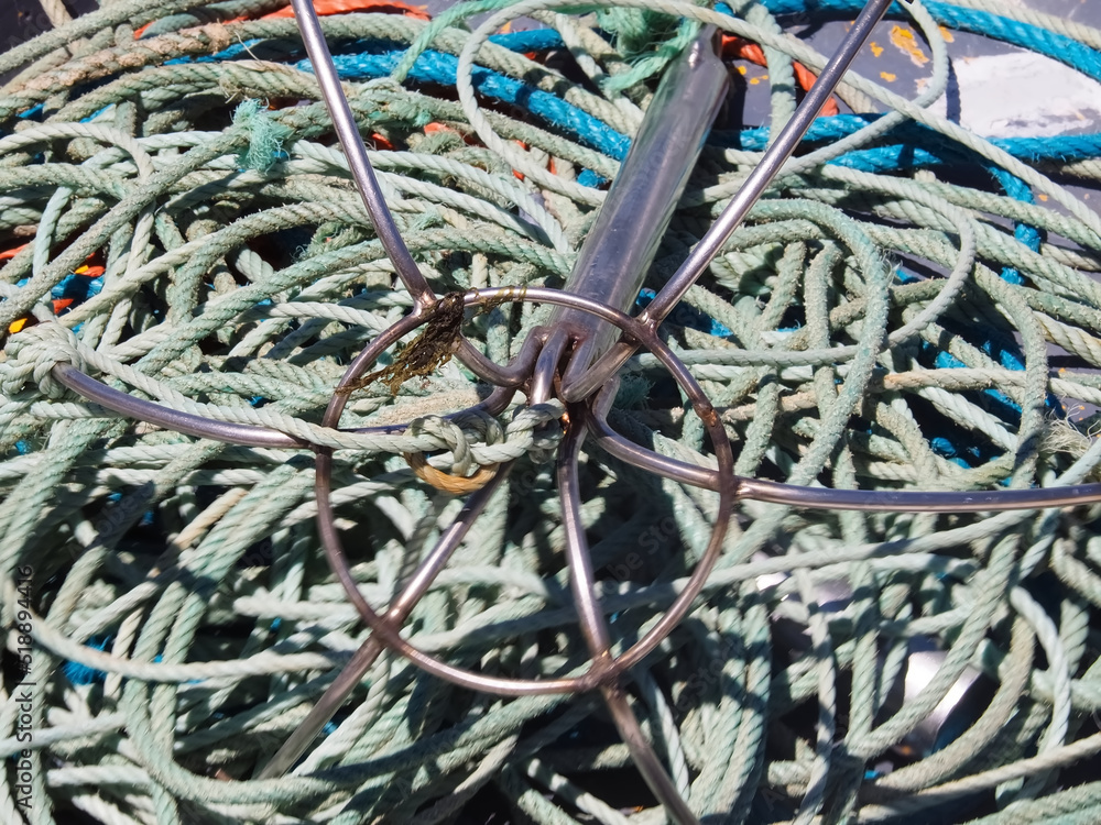 Pile of nets to catch fish with an anchor in a boat