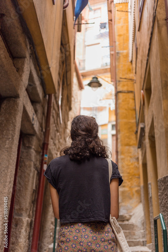 Wallpaper Mural Young woman from behind walking at narrow streets of Porto, Portugal. Summer time traveling.  Torontodigital.ca