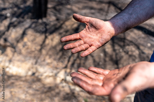 Hands of a firefighter man in the forest fire, burned forest, climate change © unai