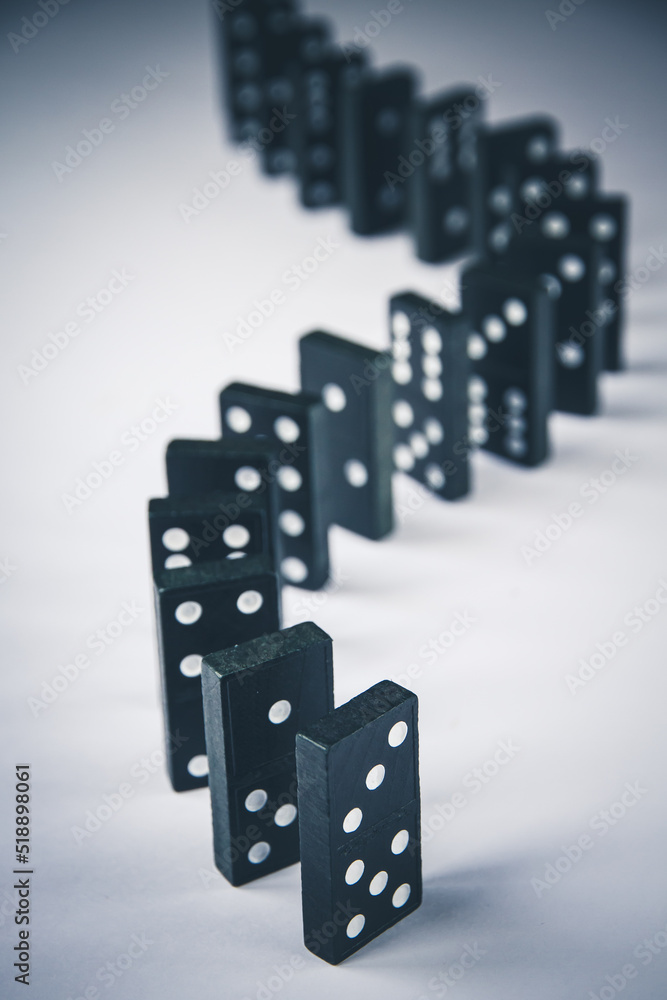 Black dominoes chain on white table background Black dominoes chain on white table background