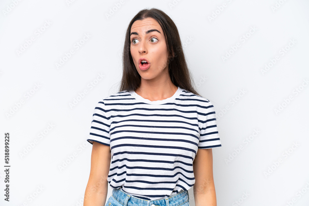 Obraz premium Young caucasian woman isolated on white background doing surprise gesture while looking to the side