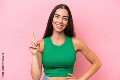 Young caucasian woman isolated on pink background showing and lifting a finger in sign of the best © luismolinero
