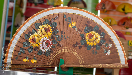 Un hermoso y tradicional abanico español con diseño floral para darse aire durante los calurosos días de verano photo