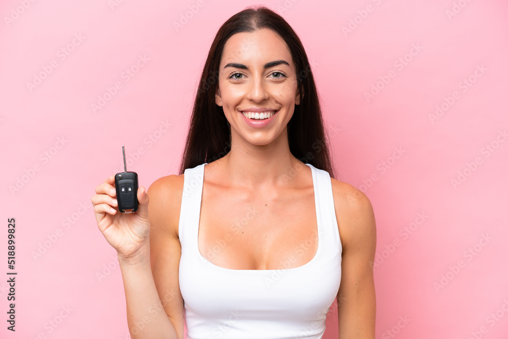 Young caucasian woman holding car keys isolated on pink background smiling a lot Young caucasian woman holding car keys isolated on pink background smiling a lot