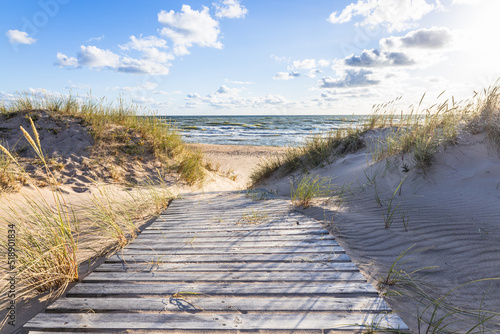 Fototapeta Naklejka Na Ścianę i Meble -  The path through dunes to the sandy beach on the Baltic Sea in summer with a blue sky
