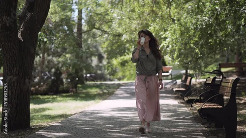 Wallpaper Mural A girl in a pink skirt walks towards the park and drinks coffee. Torontodigital.ca