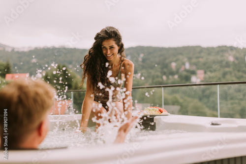 Obraz na plátně Young couple enjoying in outdoor hot tub on vacation