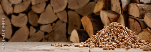 Woodpile and stack of pellets in wooden house photo