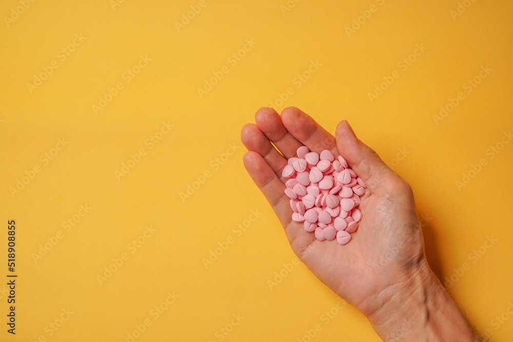 Medicine or drug in hand on yellow background. Pills for patient in hospital. Doctor ordering. Health concept. Medicine or drug in hand on yellow background. Pills for patient in hospital. Doctor ordering. Health concept.