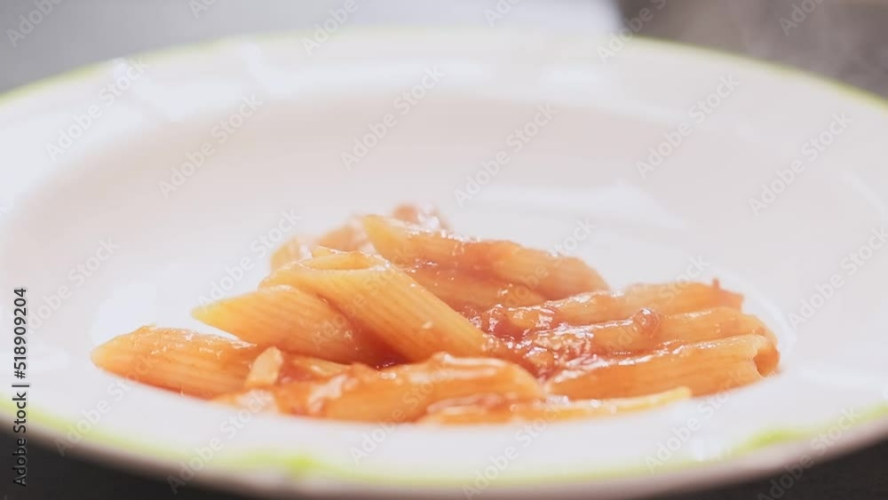 Serving pasta Arrabiata on a plate, slow motion.
Serving pasta Arrabiata on a plate, slow motion.