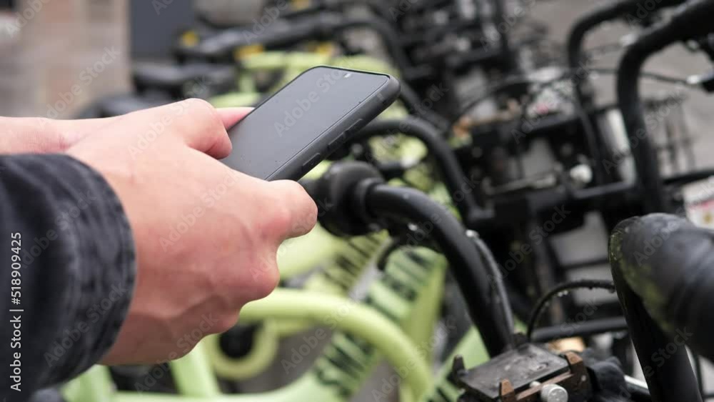 Electric scooter or bicycle in a shared parking lot, an application for a tourist phone. Alternative means of transportation using eco-transport Electric scooter or bicycle in a shared parking lot, an application for a tourist phone. Alternative means of transportation using eco-transport