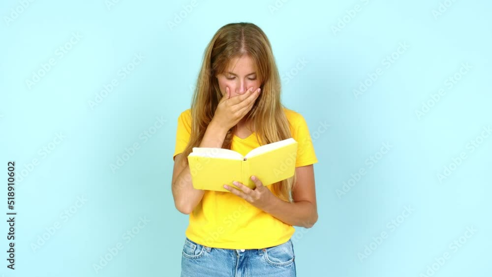 Young pretty blonde woman surprised and holding a book over isolated background Young pretty blonde woman surprised and holding a book over isolated background