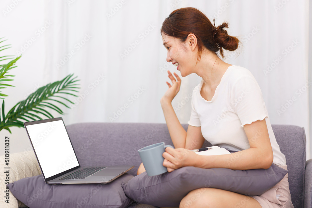 Lifestyle in living room concept, Asian woman makes greeting gesture with colleague on video call Lifestyle in living room concept, Asian woman makes greeting gesture with colleague on video call