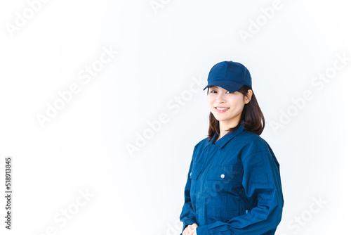 作業服を来て笑顔で仕事をする若い女性