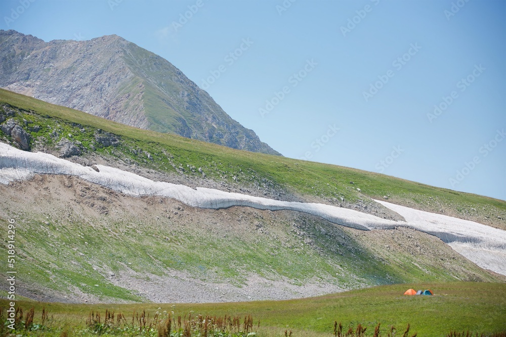 Summer mountain landscape with places of lying snow that has not lost.