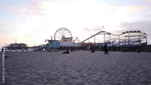 Los Angeles, California, USA, June 21, 2022: TIMELAPSE - View of Santa Monica Beach and the Pier at sunset. Santa Monica Ferris Wheel and Roller-coaster.