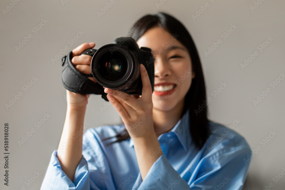 Happy Asian Woman Holding Camera Smiling Taking Photo Standing Indoors Happy Asian Woman Holding Camera Smiling Taking Photo Standing Indoors