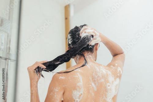 Woman Washing hair with shampoo and shower in bathroom, Asian female body and hair care with foam to freshness. Spa and Health care.