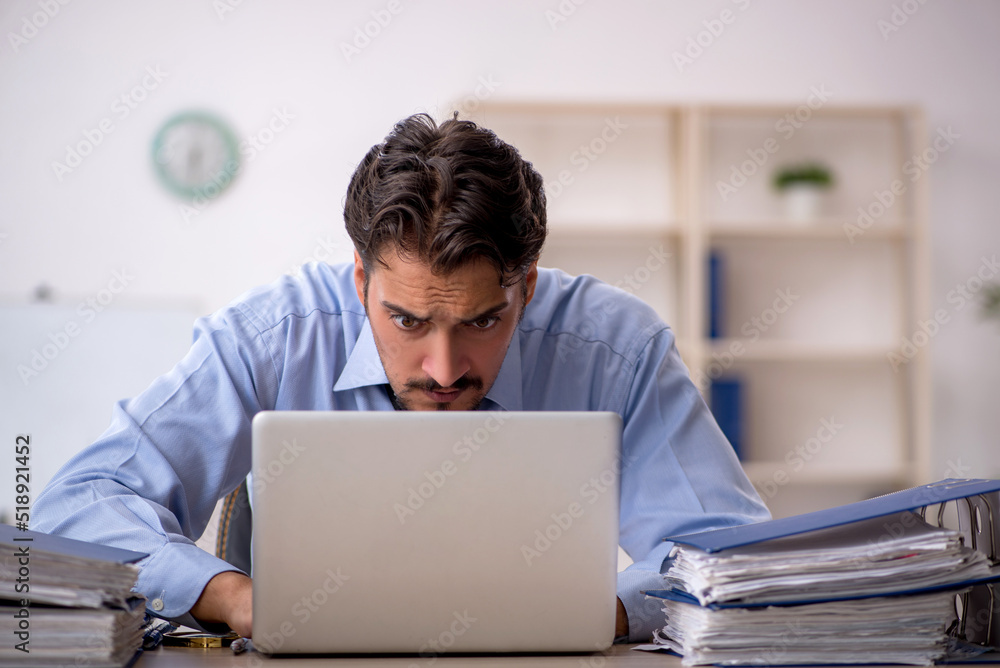 Young male employee working in the office Young male employee working in the office