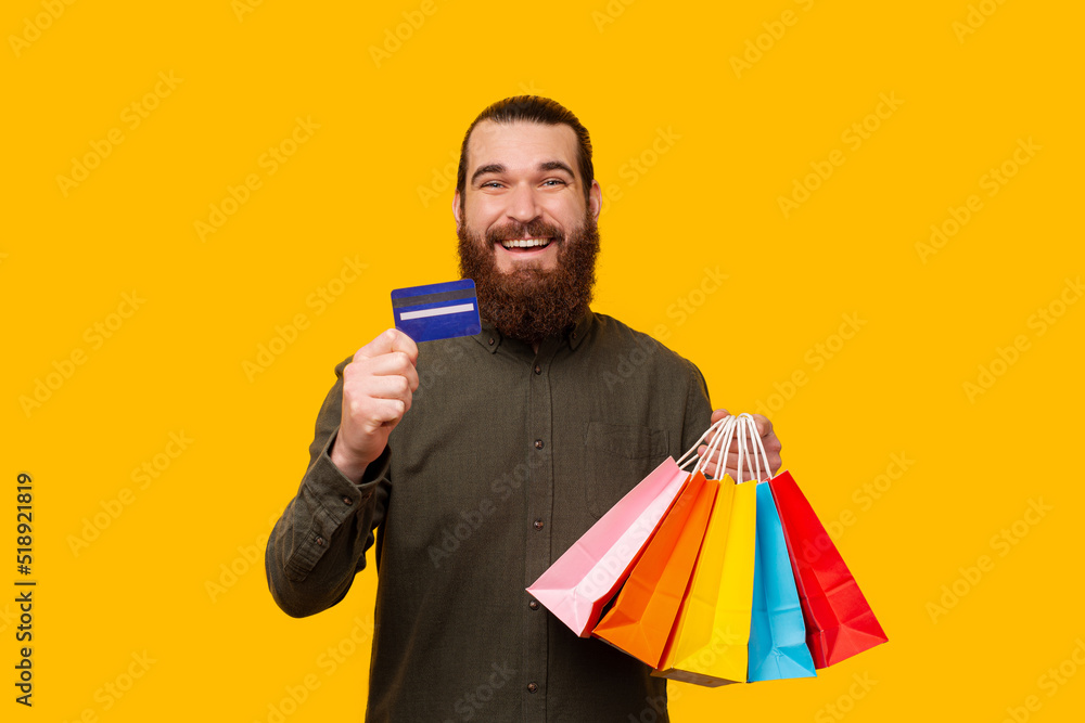 A photo of a man shopping with the credit card and looking happily at the camera A photo of a man shopping with the credit card and looking happily at the camera