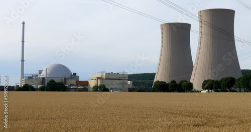 Grohnde, Germany - 07/12/2022; Nuclear power plant reactor and cooling towers. Embedded in landscape with trees, fields and forest. photo