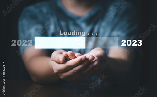 Businessman holding virtual loading bar for count down from 2022 to 2023 year of preparation merry Christmas and happy new year concept.