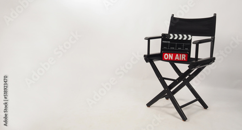 Black director chair and black clapper board and on air box on the chair on white background photo