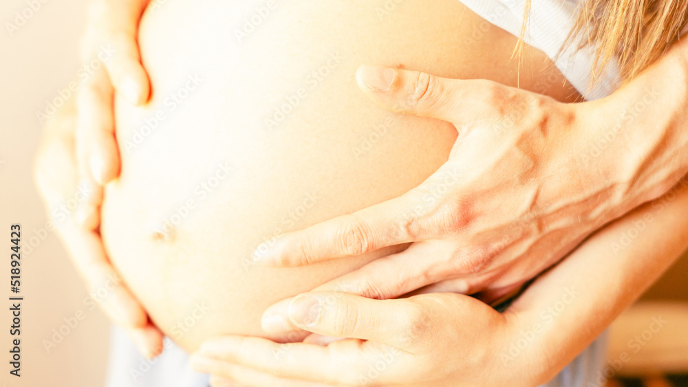 Naklejka premium Belly hands pregnant woman. Happy pregnancy woman and husband hugging pregnant belly. Concept of pregnancy, maternity, expectation for baby birth.