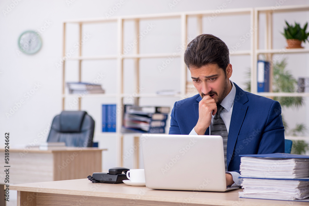 Young handsome employee working in the office Young handsome employee working in the office