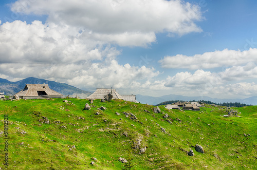 Velika Planina or Big Pasture Plateau in the Kamnik Alps, Slovenia. Mountain cottage hut or house on green hill. Alpine meadow landscape. Eco farming