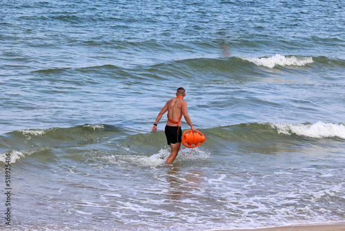 Ratownik na plaży podczas patrolowania brzegu wody. 