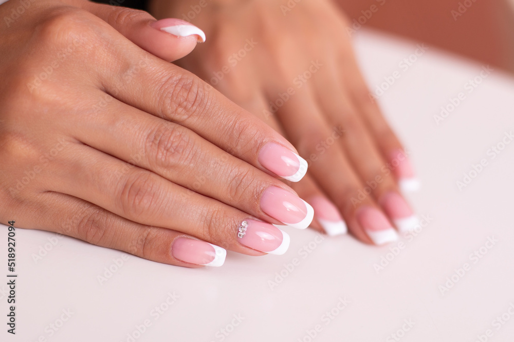 Close up view of beautiful female hands with luxury french manicure nails on white background
Close up view of beautiful female hands with luxury french manicure nails on white background