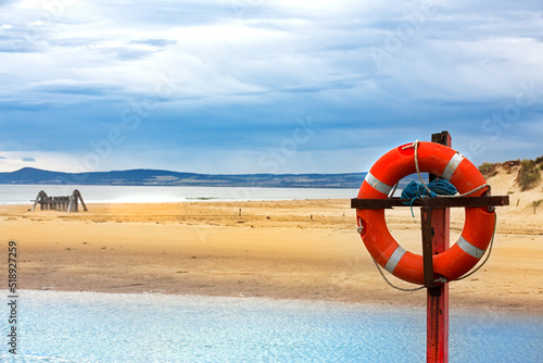 Red at white lifebuoy on sand dunes of the beach at Lossiemouth  Scotland.