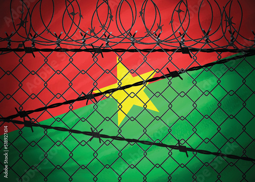 Burkina Faso flag behind barbed wire and metal fence