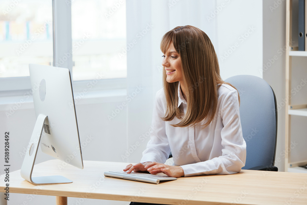 Cheerful happy adorable blonde businesswoman worker freelancer look at screen work on desktop computer online in light modern office. Happy employee typing quarterly report. Copy space, remote job Cheerful happy adorable blonde businesswoman worker freelancer look at screen work on desktop computer online in light modern office. Happy employee typing quarterly report. Copy space, remote job
