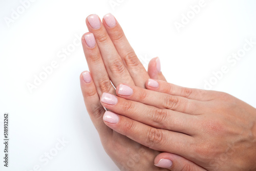 Woman hands pink manicure on white background