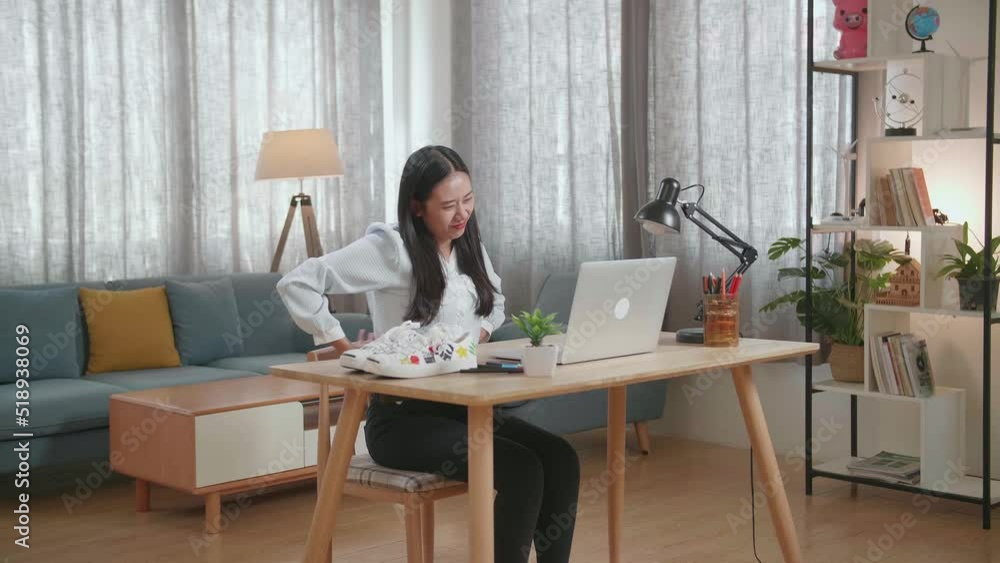 Asian Female Footwear Designer Having A Backache While Working On A Laptop At Home
