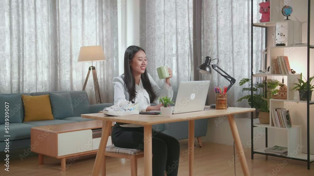 Smiling Asian Female Footwear Going Through The Room, Sits Down And Starts Working At Her Laptop
