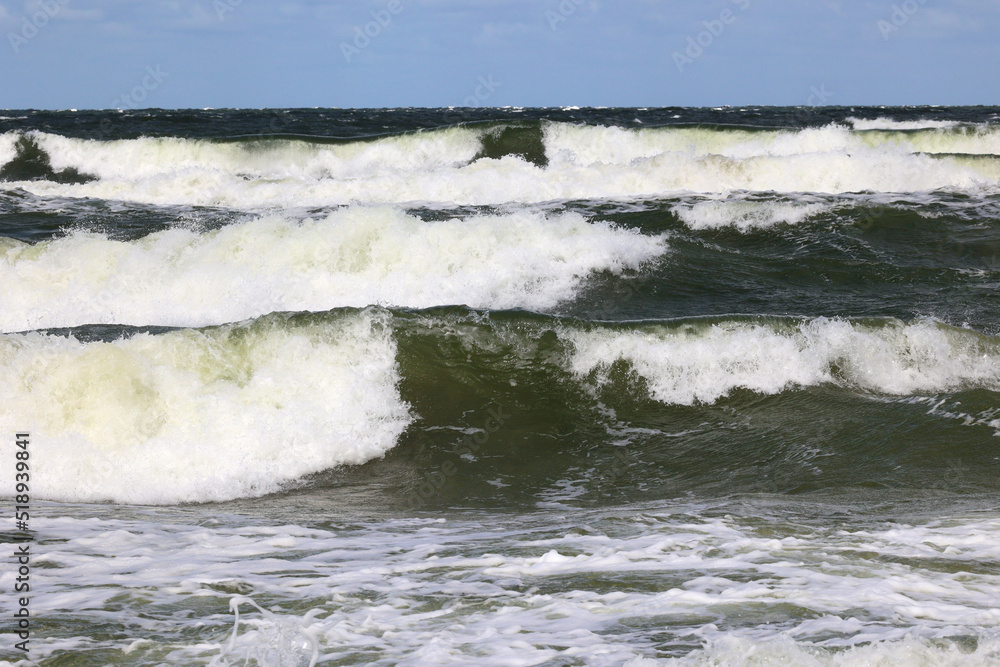 Duża morska fala rozbija się o falochron  na wybrzeżu - obrazy, fototapety, plakaty 
