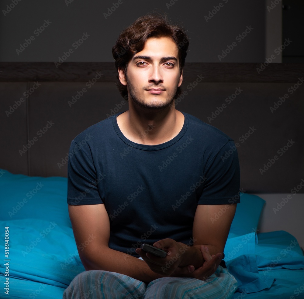 Man watching tv at night in bed Man watching tv at night in bed