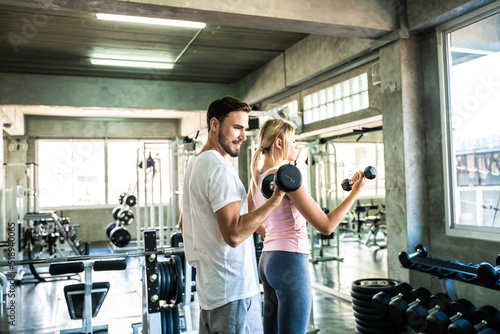 Smart sport man and woman working out in fitness gym