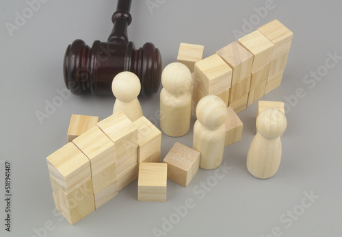 Gavel breaking wall with people figures on gray background. Court and laws making people free concept.