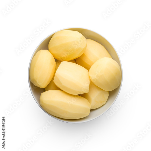 Raw peeled potatoes in bowl isolated on white background, top view