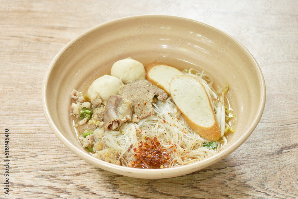 vermicelli rice noodles topping chop boiled pork and fish ball in soup dressing cayenne pepper on bowl vermicelli rice noodles topping chop boiled pork and fish ball in soup dressing cayenne pepper on bowl