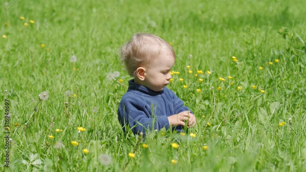 Happy kid playing on green grass on a sunny day, 1.5 year old child in the park in summer. Happy kid playing on green grass on a sunny day, 1.5 year old child in the park in summer.
