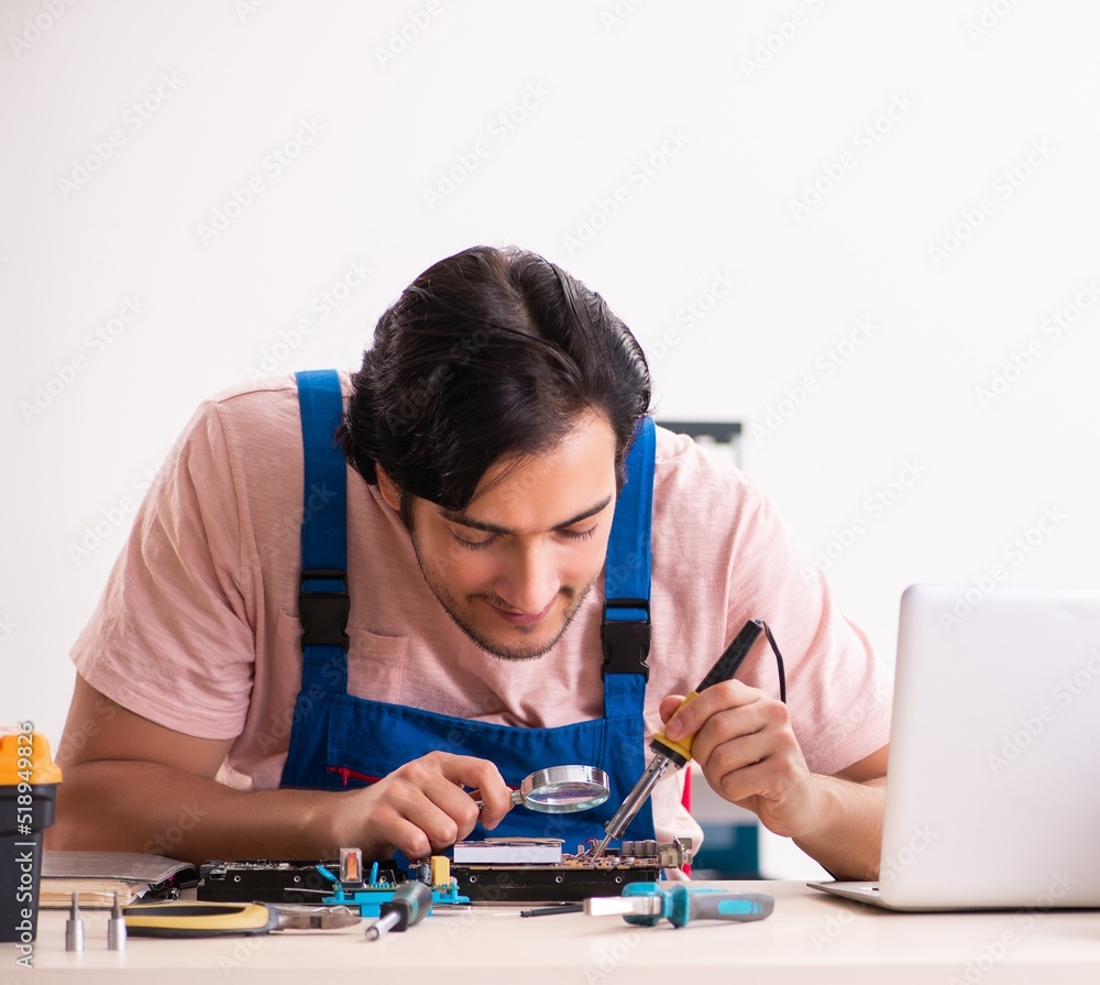 Young male contractor repairing computer Young male contractor repairing computer
