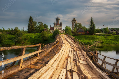 Kenozero National Park in the Arkhangelsk Region, the Ryazhevoy Bridge across the Kena River and the Pyatnitskaya Church in the village of Izmailovskaya photo