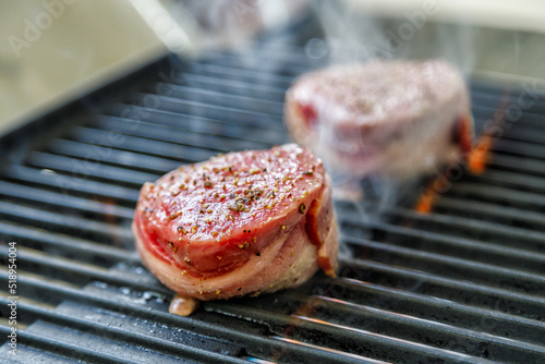 Bacon wrapped filet mignon steak on camping grill