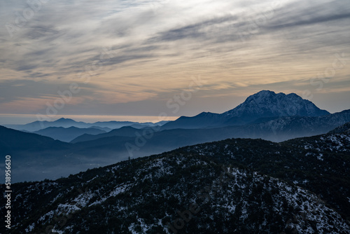 Beautiful view of a snowy landscape with a sunset and mountains behind with "La Campana" hill in the background